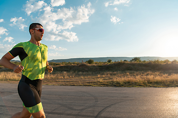 Image showing Triathlete in professional gear running early in the morning, preparing for a marathon, dedication to sport and readiness to take on the challenges of a marathon.