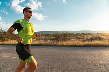 Image showing Triathlete in professional gear running early in the morning, preparing for a marathon, dedication to sport and readiness to take on the challenges of a marathon.