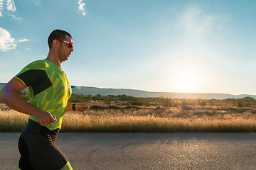 Image showing Triathlete in professional gear running early in the morning, preparing for a marathon, dedication to sport and readiness to take on the challenges of a marathon.