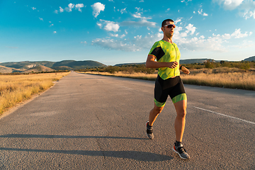 Image showing Triathlete in professional gear running early in the morning, preparing for a marathon, dedication to sport and readiness to take on the challenges of a marathon.