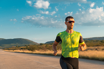 Image showing Triathlete in professional gear running early in the morning, preparing for a marathon, dedication to sport and readiness to take on the challenges of a marathon.