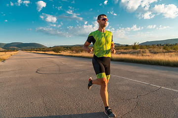 Image showing Triathlete in professional gear running early in the morning, preparing for a marathon, dedication to sport and readiness to take on the challenges of a marathon.