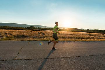 Image showing Triathlete in professional gear running early in the morning, preparing for a marathon, dedication to sport and readiness to take on the challenges of a marathon.