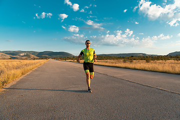 Image showing Triathlete in professional gear running early in the morning, preparing for a marathon, dedication to sport and readiness to take on the challenges of a marathon.