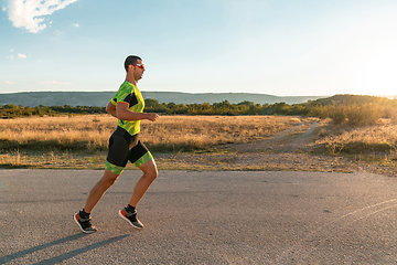 Image showing Triathlete in professional gear running early in the morning, preparing for a marathon, dedication to sport and readiness to take on the challenges of a marathon.