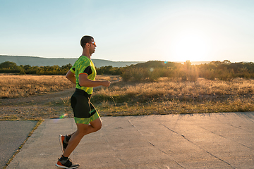 Image showing Triathlete in professional gear running early in the morning, preparing for a marathon, dedication to sport and readiness to take on the challenges of a marathon.