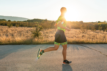 Image showing Triathlete in professional gear running early in the morning, preparing for a marathon, dedication to sport and readiness to take on the challenges of a marathon.