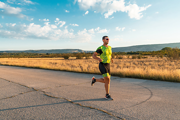 Image showing Triathlete in professional gear running early in the morning, preparing for a marathon, dedication to sport and readiness to take on the challenges of a marathon.