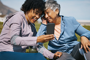 Image showing Senior woman, friends and listening to phone with earphones or outdoor for a video call, fitness podcast or announcement. Smile, share and people with headphones at the beach together with smartphone