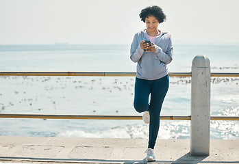 Image showing Fitness, beach and woman with a cellphone, typing and social media with network, sports and smile. Happy person, athlete and seaside with a smartphone, internet connection and contact with exercise