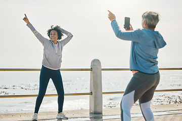 Image showing Photograph, senior woman and friends fitness with social media post feeling silly by the sea. Training, exercise and workout with mature people and photo for profile picture with pointing by ocean