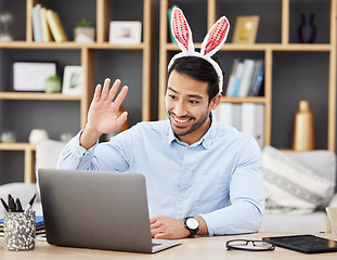 Image showing Businessman, bunny ears and video call at home in online meeting with computer screen and wave greeting. Remote work, holiday and rabbit costume for digital education class with male teacher at house