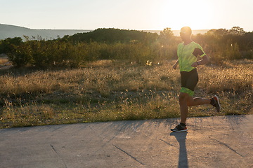 Image showing Triathlete in professional gear running early in the morning, preparing for a marathon, dedication to sport and readiness to take on the challenges of a marathon.