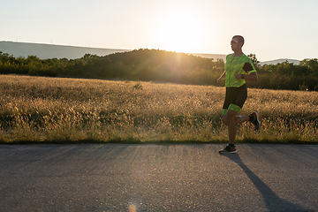 Image showing Triathlete in professional gear running early in the morning, preparing for a marathon, dedication to sport and readiness to take on the challenges of a marathon.