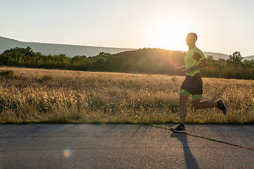 Image showing Triathlete in professional gear running early in the morning, preparing for a marathon, dedication to sport and readiness to take on the challenges of a marathon.