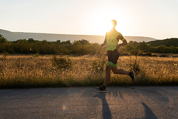 Image showing Triathlete in professional gear running early in the morning, preparing for a marathon, dedication to sport and readiness to take on the challenges of a marathon.