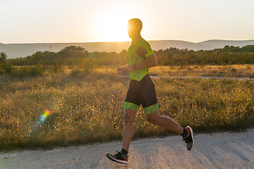 Image showing Triathlete in professional gear running early in the morning, preparing for a marathon, dedication to sport and readiness to take on the challenges of a marathon.