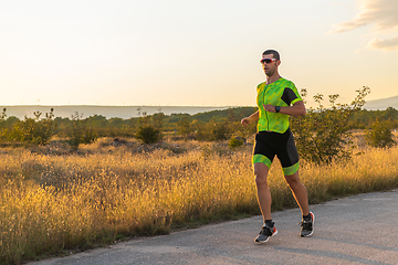 Image showing Triathlete in professional gear running early in the morning, preparing for a marathon, dedication to sport and readiness to take on the challenges of a marathon.