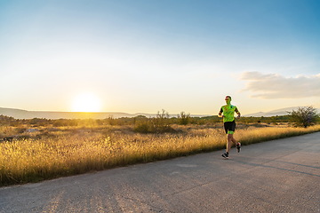 Image showing Triathlete in professional gear running early in the morning, preparing for a marathon, dedication to sport and readiness to take on the challenges of a marathon.