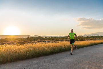 Image showing Triathlete in professional gear running early in the morning, preparing for a marathon, dedication to sport and readiness to take on the challenges of a marathon.