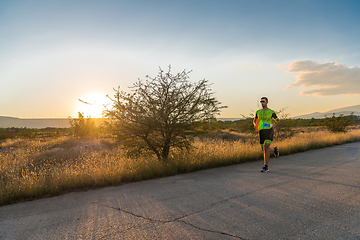 Image showing Triathlete in professional gear running early in the morning, preparing for a marathon, dedication to sport and readiness to take on the challenges of a marathon.