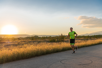 Image showing Triathlete in professional gear running early in the morning, preparing for a marathon, dedication to sport and readiness to take on the challenges of a marathon.