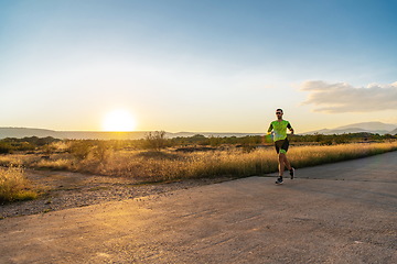 Image showing Triathlete in professional gear running early in the morning, preparing for a marathon, dedication to sport and readiness to take on the challenges of a marathon.