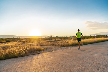 Image showing Triathlete in professional gear running early in the morning, preparing for a marathon, dedication to sport and readiness to take on the challenges of a marathon.