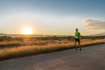 Image showing Triathlete in professional gear running early in the morning, preparing for a marathon, dedication to sport and readiness to take on the challenges of a marathon.