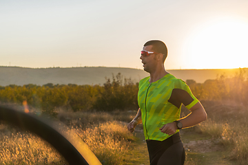 Image showing Triathlete in professional gear running early in the morning, preparing for a marathon, dedication to sport and readiness to take on the challenges of a marathon.