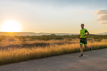 Image showing Triathlete in professional gear running early in the morning, preparing for a marathon, dedication to sport and readiness to take on the challenges of a marathon.