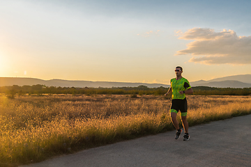 Image showing Triathlete in professional gear running early in the morning, preparing for a marathon, dedication to sport and readiness to take on the challenges of a marathon.