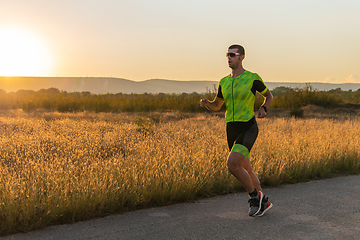 Image showing Triathlete in professional gear running early in the morning, preparing for a marathon, dedication to sport and readiness to take on the challenges of a marathon.