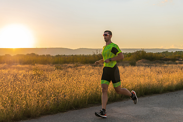 Image showing Triathlete in professional gear running early in the morning, preparing for a marathon, dedication to sport and readiness to take on the challenges of a marathon.