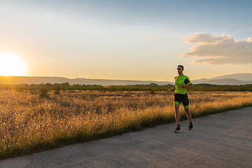 Image showing Triathlete in professional gear running early in the morning, preparing for a marathon, dedication to sport and readiness to take on the challenges of a marathon.