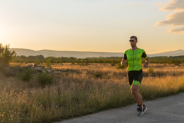 Image showing Triathlete in professional gear running early in the morning, preparing for a marathon, dedication to sport and readiness to take on the challenges of a marathon.