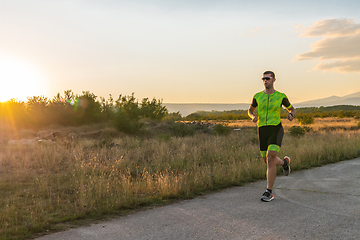 Image showing Triathlete in professional gear running early in the morning, preparing for a marathon, dedication to sport and readiness to take on the challenges of a marathon.