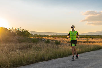 Image showing Triathlete in professional gear running early in the morning, preparing for a marathon, dedication to sport and readiness to take on the challenges of a marathon.