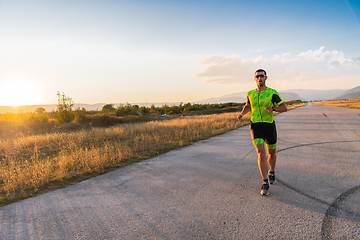 Image showing Triathlete in professional gear running early in the morning, preparing for a marathon, dedication to sport and readiness to take on the challenges of a marathon.