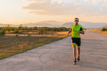 Image showing Triathlete in professional gear running early in the morning, preparing for a marathon, dedication to sport and readiness to take on the challenges of a marathon.