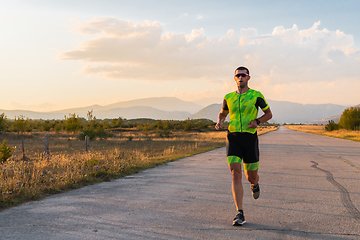 Image showing Triathlete in professional gear running early in the morning, preparing for a marathon, dedication to sport and readiness to take on the challenges of a marathon.