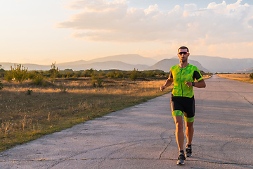 Image showing Triathlete in professional gear running early in the morning, preparing for a marathon, dedication to sport and readiness to take on the challenges of a marathon.