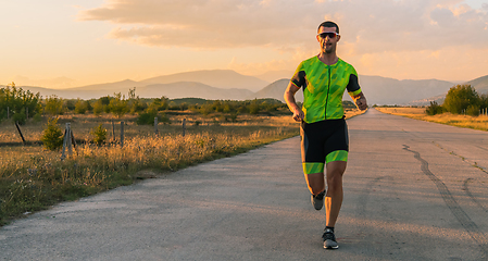 Image showing Triathlete in professional gear running early in the morning, preparing for a marathon, dedication to sport and readiness to take on the challenges of a marathon.