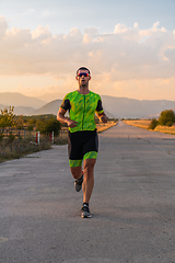 Image showing Triathlete in professional gear running early in the morning, preparing for a marathon, dedication to sport and readiness to take on the challenges of a marathon.