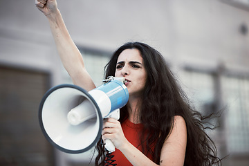 Image showing Megaphone, woman and shouting for social change, justice for equality and humanity with activist on street, stand up and strike. Young female, protester and girl with bullhorn, protesting for freedom