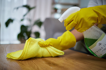 Image showing Person, hands and cloth with detergent for cleaning table, housekeeping or germ and bacteria at home. Closeup of maid, cleaner or housekeeper with gloves and spray on furniture desk for clean hygiene