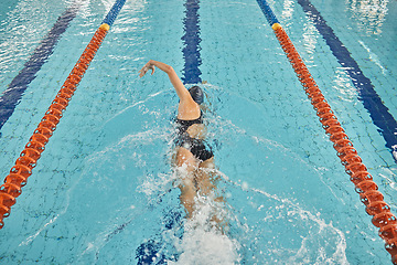 Image showing Person, freestyle and swimming in pool for sports competition, challenge and fitness training. Athlete, woman and swimmer in workout exercise for water race stroke, speed and triathlon championship