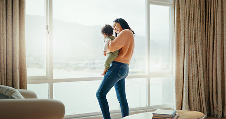 Image showing Care, happy and a mother with a baby in a house and looking at the view from a window. Smile, hug and a young mom holding a child for playing, bonding or love together in the morning as family