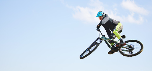 Image showing Mountain bike, man and jump in blue sky for competition, freedom or adventure on mockup space. Banner of athlete, sports and bicycle in air for action, cardio race and courage of stunt, speed or risk