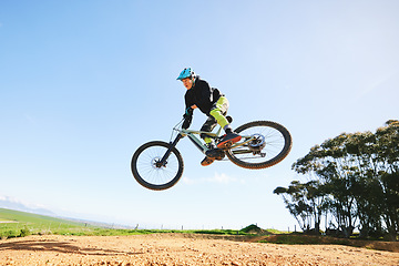 Image showing Mountain bike, man and jump in blue sky for action, stunt performance and speed on mockup space. Bicycle, sports athlete and courage in air for freedom, risk or race in cycling competition with power